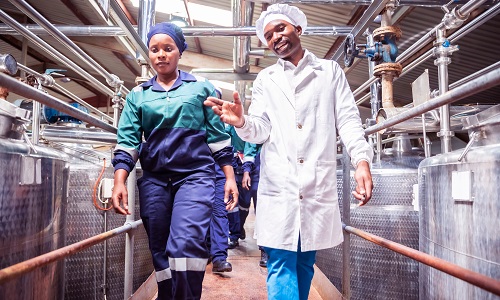 Female Factory Worker Walking with Her Supervisor at a Factory in Zambia.