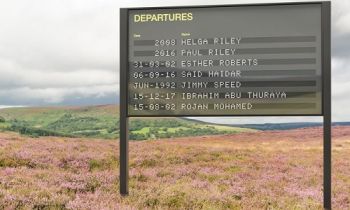 Departures board displaying dates and names in the middle of a field