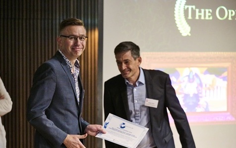 James Robson holding the Universtity Outreach Award certificate