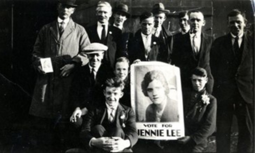 ILP (Independent Labour Party) members crowded around a poster featuring a photo of Jennie Lee and "Vote for Jennie Lee"