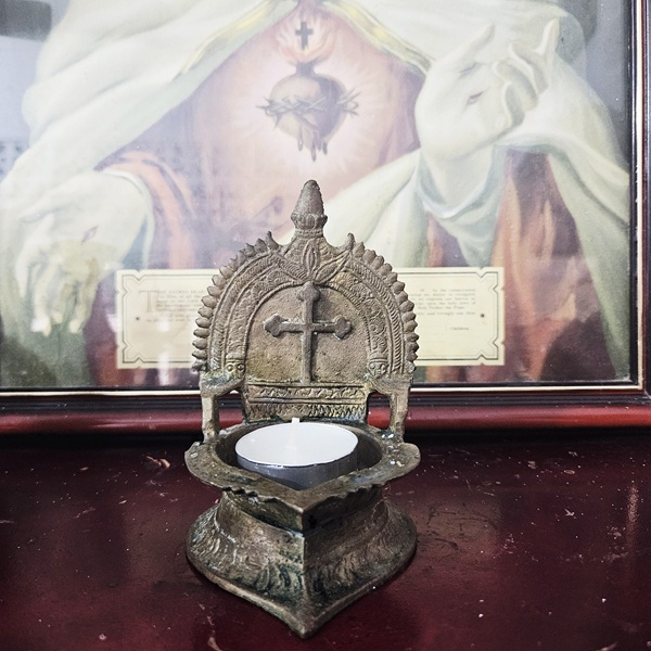 A close-up of an old Indian brass prayer lamp that belonged to Shanthini’s paternal grandmother, etched with a cross indicating its Indian Christian identity