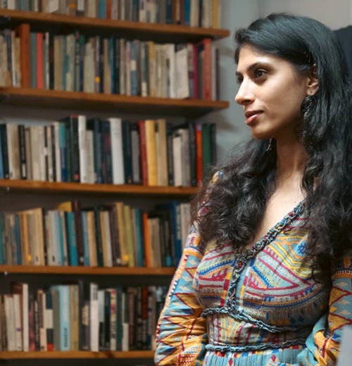 Dr. Keshia in front of a bookshelf at Rumah Attap Library and Collective
