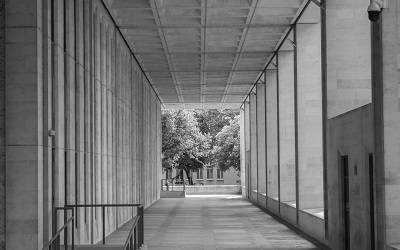 Photo by Jeremy Segrott - photo is black and white and shows a long corridor in the Welsh Government Building, Cardiff, taken 2016. At the end are trees.
