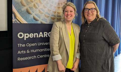 Gemma Allen and Adrienne Scullion facing forwards smiling, standing in front of a OpenARC pull-up banner