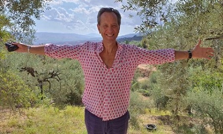 Actor Richard E Grant with arms outstretched
