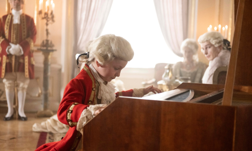 A young Mozart plays the harpsichord in front of an elite audience 