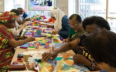 Image credit: Marcia Chandra, a Stitch in Time, Who Are We? Project, 2018. Courtesy of Counterpoints Arts. Image of a group of women sewing together.
