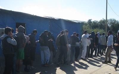 Men queuing for food in the former 'Jungle' refugee camp in Calais, taken 2015 by Heidi McCafferty
