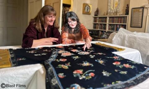 @Blast Films two person looks at an flower embroidery on the table