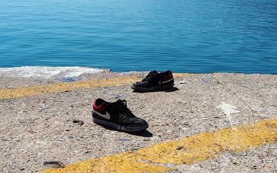 Two shoes lie next to the sea on the island of Lesbos, Greece