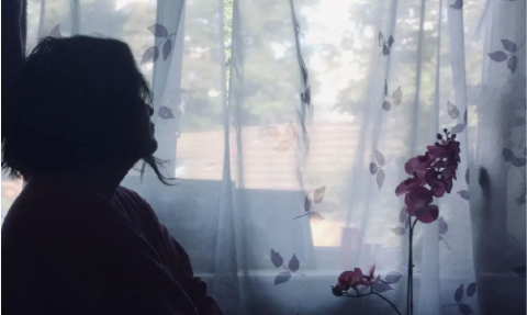 Silhouette of a women against a sunlit window