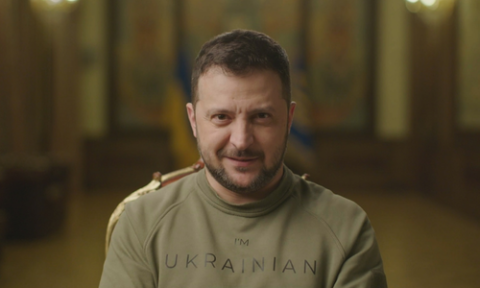 President Zelensky wearing an army green t-shirt with the words I'M UKRAINIAN, stares down the camera lens